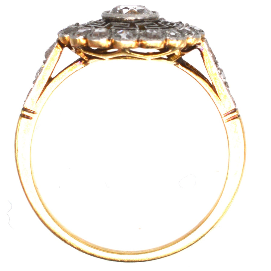 Art Deco 18ct gold and platinum target diamond ring with Greek key details, showcasing a vintage design.