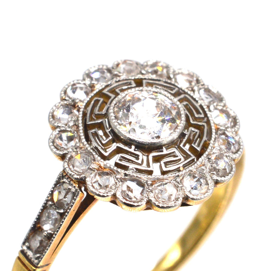 Art Deco 18ct gold and platinum ring with target diamond and Greek key details, showcasing vintage elegance.