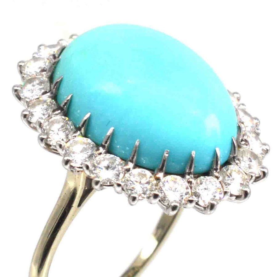 Vintage turquoise and diamond cluster cocktail ring featuring an oval turquoise center stone with 20 sparkling diamonds.